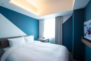 福冈Prince Smart Inn Hakata的一间蓝色的卧室,配有白色的床和电视
