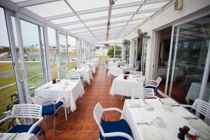 阿尼斯顿阿尼斯顿Spa酒店的餐厅设有白色的桌椅和窗户。