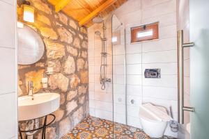 卡斯Kaş Joy Glamping的一间带水槽和石墙的浴室