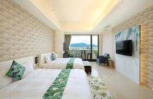 鱼池乡湖悦景观旅店的酒店客房设有两张床和一台平面电视。