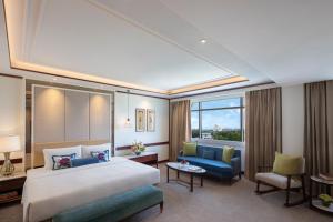 阿格拉Tajview Agra-IHCL SeleQtions的酒店客房设有一张大床和一张沙发。
