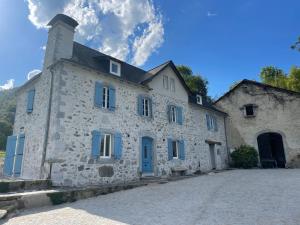 ArudyLe Val Éveillé 4 étoiles - maison de maître de 1773的街上一座带蓝色百叶窗的古老石头建筑