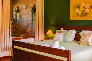 维奥康德马奥Pousada do Sonho的一间卧室设有一张带绿色墙壁的大床