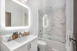 安娜堡Exhibit A2的白色的浴室设有水槽和淋浴。