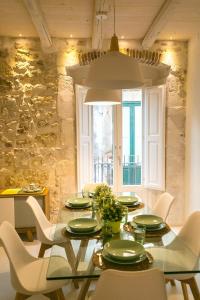 锡拉库扎Veronique by Dimore in Sicily的一间设有玻璃桌和白色椅子的用餐室