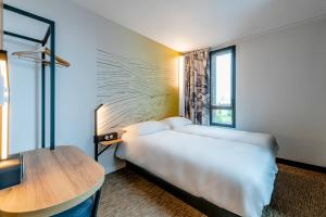 德勒B&B HOTEL Dreux Nord的酒店客房配有一张床铺和一张桌子。