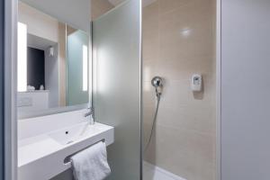 德勒B&B HOTEL Dreux Nord的带淋浴、水槽和镜子的浴室