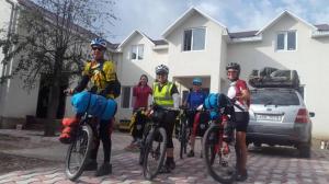 卡拉科尔Snow Leopard Hostel的一群人骑着自行车在房子前面