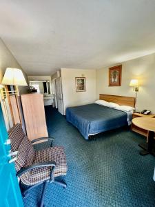 福雷斯特城Rest Inn Motel的酒店客房带一张床、一张桌子和椅子