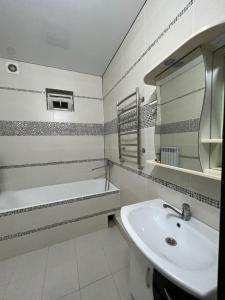 奇姆肯特MINI HOTEL COMFORT的一间带水槽、浴缸和镜子的浴室