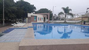 曼塔Relax Habitación Privada的一座带两把椅子的游泳池以及一座建筑