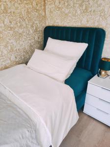 纽伦堡VogelsNest的一张带蓝色床头板、白色床单和枕头的床