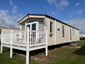 ScratbyFulmar 16, Scratby - California Cliffs, Parkdean, sleeps 6, pet friendly - 2 minutes from the beach!的移动房屋设有白色栏杆和门廊