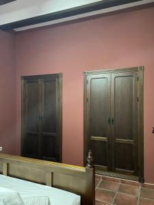 Lora del RíoCasa Los pinceles de Murillo的卧室设有2个木橱柜和粉红色的墙壁
