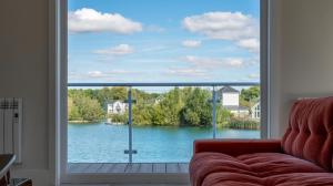 南塞尔尼Gorgeous 4 bedroom Cotswolds home with lake view的客厅设有窗户,享有湖景