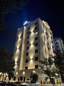 木浦市Hotel Yaja Mokpo Peace Square的一座高大的白色建筑,上面有灯