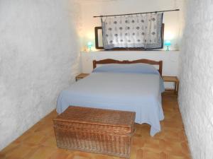 马西亚娜马里纳Cotetonda - Appartamento Ilvia的一间卧室配有一张床和一张柳条桌