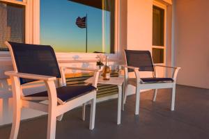 格洛斯特格洛斯特亚特兰蒂斯海滨酒店的门廊上的两把椅子和一张桌子