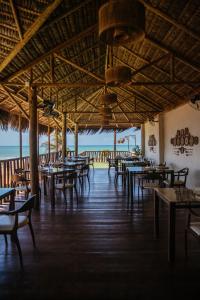 杰里科科拉Hurricane Jeri的一间空餐厅,配有桌椅,享有海景