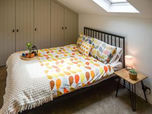 纳尔斯伯勒Dove Cottage的一间卧室配有一张床和一张带床罩的桌子