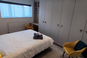 博勒姆伍德Comfortable 1 Bed flat with Air Con的一间卧室配有一张床、两把椅子和一张书桌
