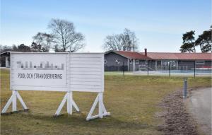费尔耶斯塔登Nice Apartment In Frjestaden With Kitchen的坐在建筑物前面的草上的一个白色标志