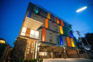 华欣华欣石雕头像酒店的一座晚上有色彩缤纷的外观的建筑