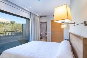 巴拉格尔HOTEL JAUME D'URGELL的卧室设有白色的床和大窗户