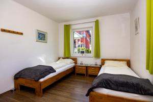 克夫拉赫克夫拉赫公寓的配有绿窗帘和窗户的客房内的两张床