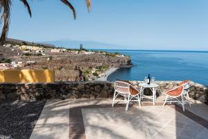 圣地亚哥海滩Casa Los Mangos - Increíbles vistas的俯瞰大海的庭院内的桌椅