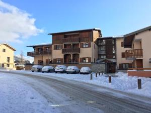 欧苏瓦Appartement Aussois, 2 pièces, 4 personnes - FR-1-508-187的积雪的街道,汽车停在大楼前