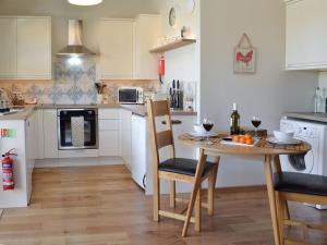 MountfieldThe Hayloft-ukc2489的厨房配有木桌和桌椅