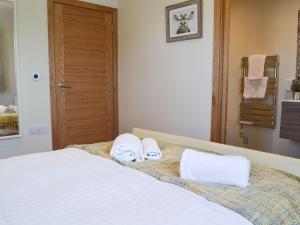 MountfieldThe Hayloft-ukc2489的一间卧室配有一张床,上面有两条毛巾
