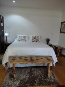 特雷齐蒂利亚斯Viena Hospedaria的卧室配有白色的床和木凳