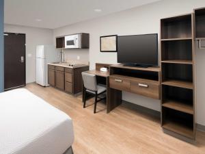 梅里马克Extended Stay America Suites - Nashua - Merrimack的酒店客房配有一张床和一张书桌及一台电视