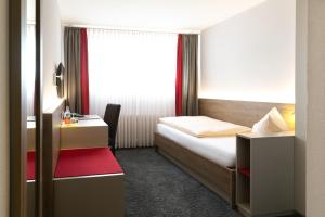 弗莱堡比尔豪斯尔餐厅酒店的一间卧室配有一张床、一张书桌和一个窗户。