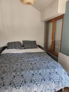 奥尔沃L'Absolu的一间卧室配有一张带蓝色和白色棉被的床