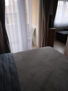 普里什蒂纳Gray Apartament 2 Pristina的一间卧室设有一张床和一个大窗户