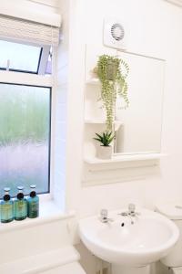 曼彻斯特Bee Stays - Caldecott House的白色的浴室设有水槽和窗户。