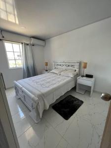 圣安德烈斯ARNAS HOME的白色的卧室设有一张大床和一个窗户