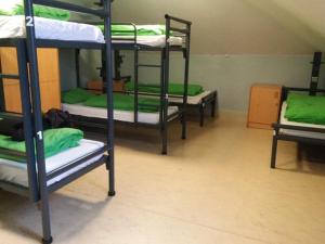 伦敦Bell House Hostel的带绿色床单的客房内的三张双层床