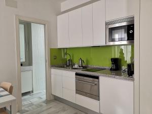 塞维利亚White Loft Alameda的厨房配有白色橱柜和绿色墙壁