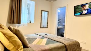 阿格诺Regina Bed & Breakfast的卧室配有一张床,墙上配有电视。