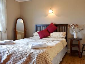 HamsterleyCotswolds Cottage的一间卧室配有一张床,上面有两条毛巾