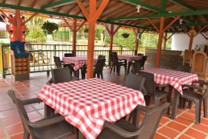 蒙特内哥罗Finca Hotel Villa Mariana的餐厅设有桌椅和红白格子桌
