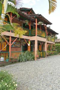 蒙特内哥罗Finca Hotel Villa Mariana的带阳台的木屋和棕榈树