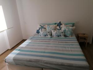 拉帕洛La conchiglia的一张带蓝色和白色床单及枕头的床