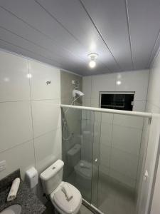 佩尼亚Do Parque Pousada Comfort的一间带卫生间和玻璃淋浴间的浴室