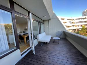 雷克雅未克Cosy and spacious apartment in Reykjavik的阳台配有白色沙发和桌子