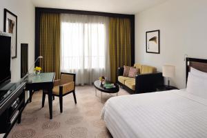 迪拜Avani Deira Dubai Hotel的酒店客房设有床和客厅。